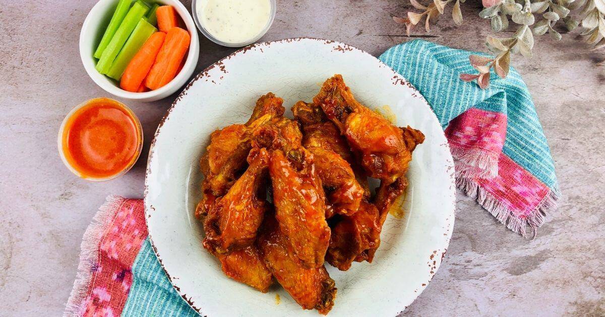 buffalo chicken wings on a plate with sides and dipping sauce