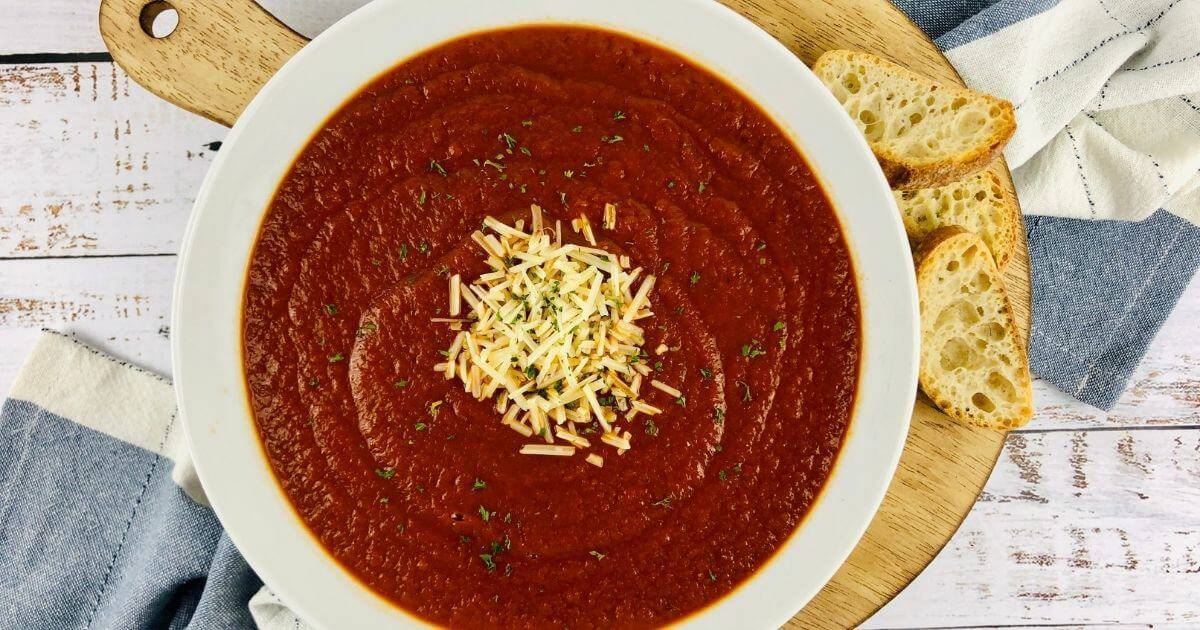 bowl of gluten free tomato soup on board with bread
