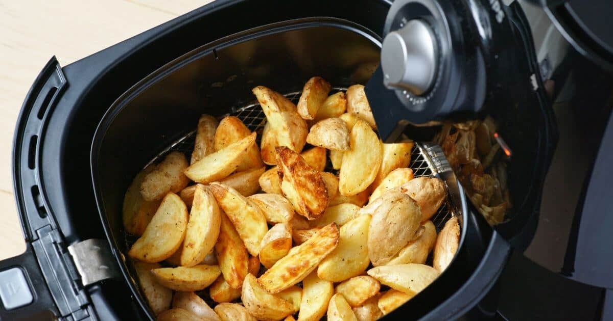 close up of air fryer cooking crispy fries in the basket.