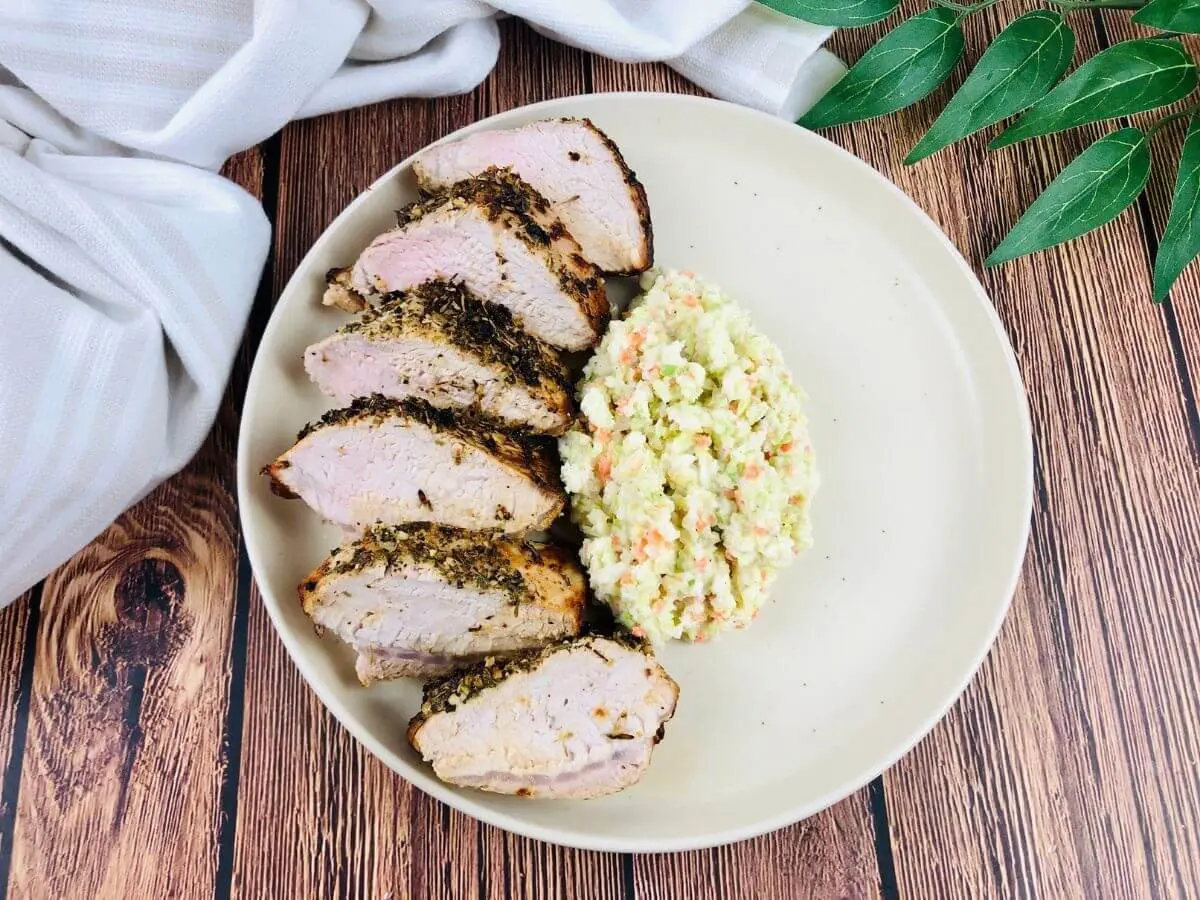 air fryer pork tenderloin on a white plate with slaw