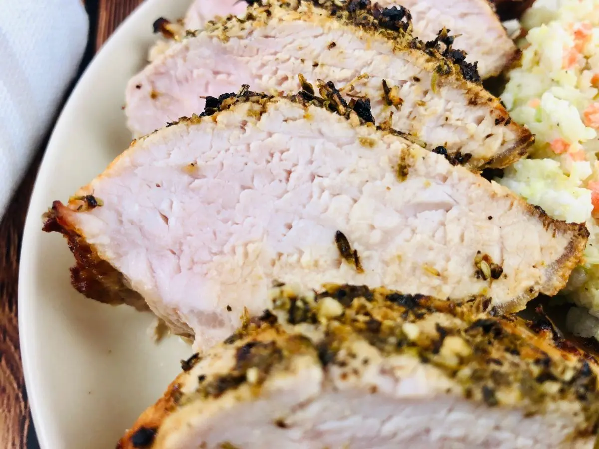 slice air fryer pork tenderloin on a plate with slaw