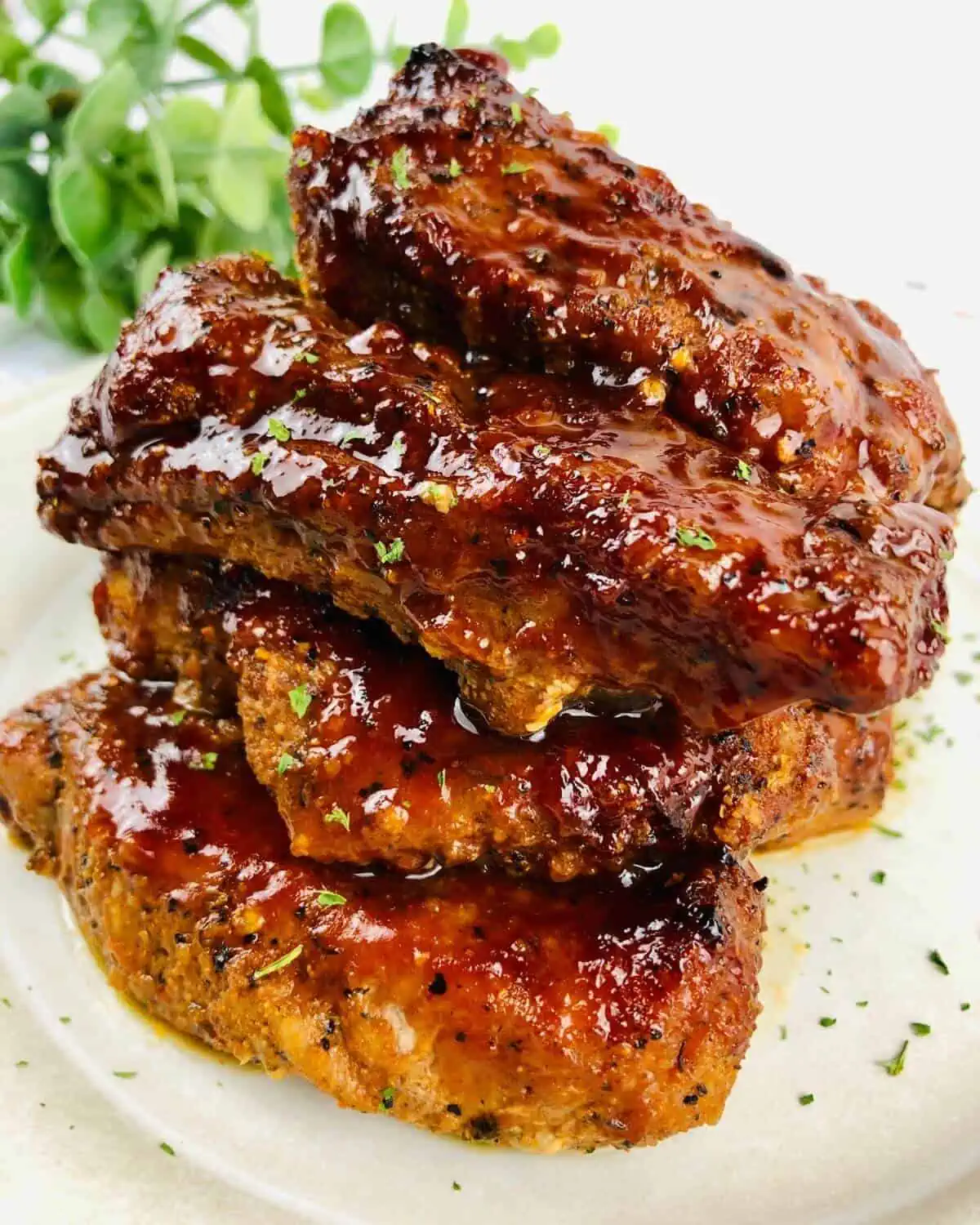 Cooked and sauced pork ribs on a white plate.