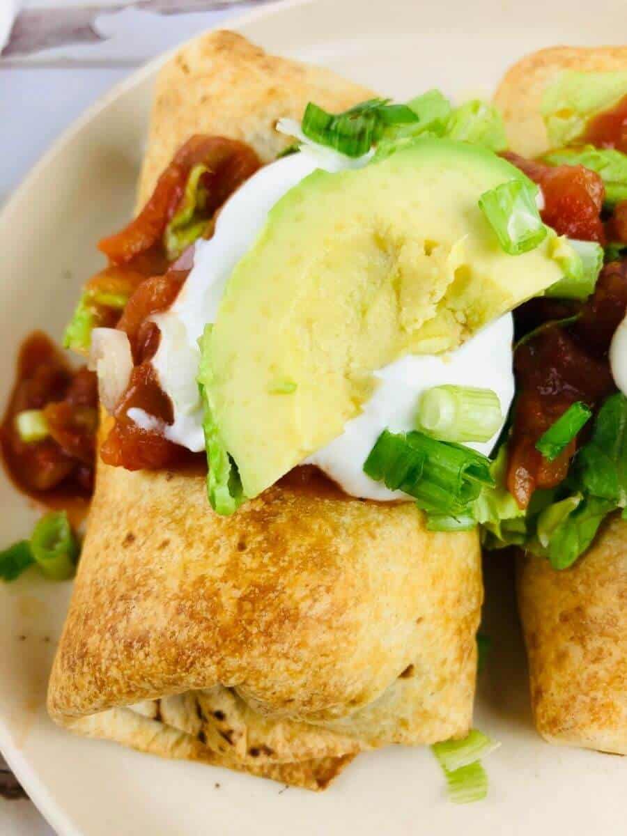 Close up image of air fryer chimichanga loaded with toppings.