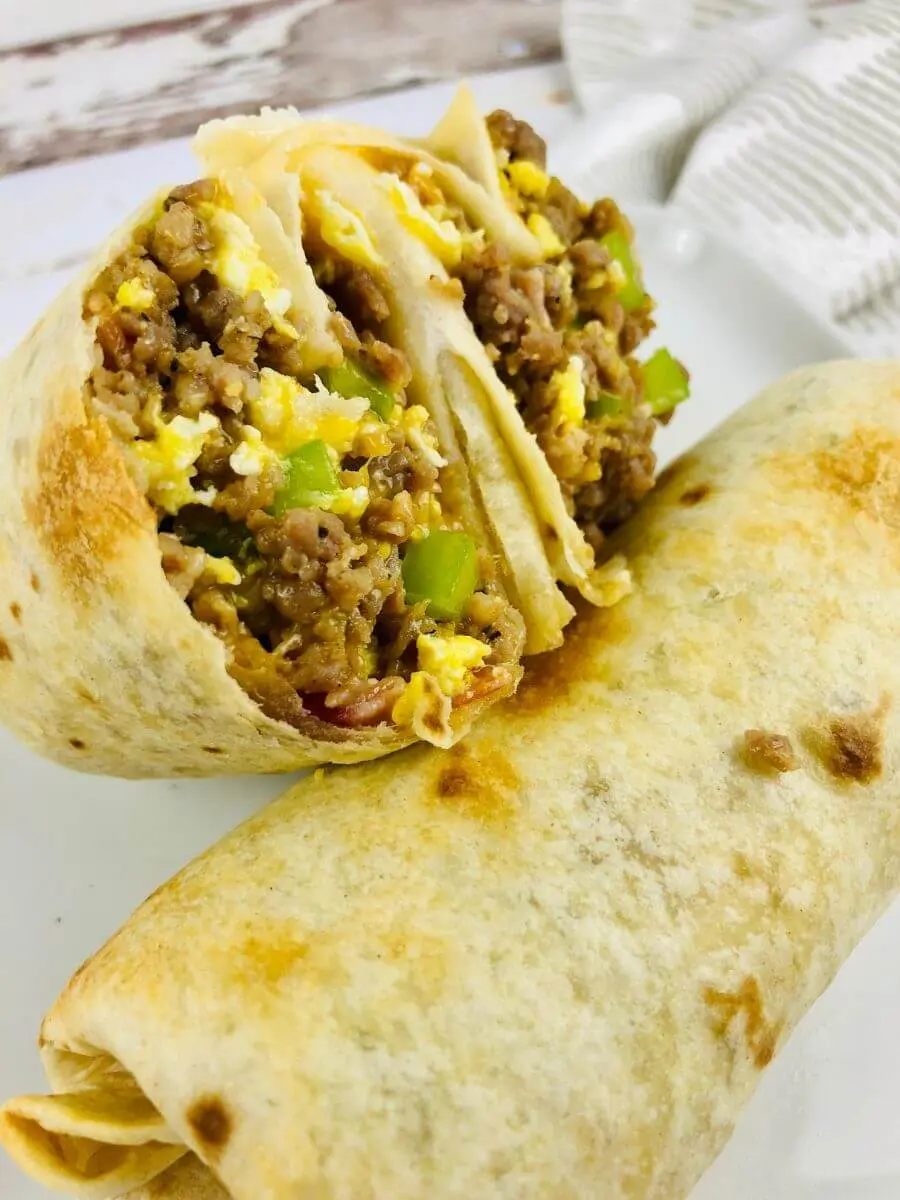 close up of air fryer breakfast burritos cut and on a plate.