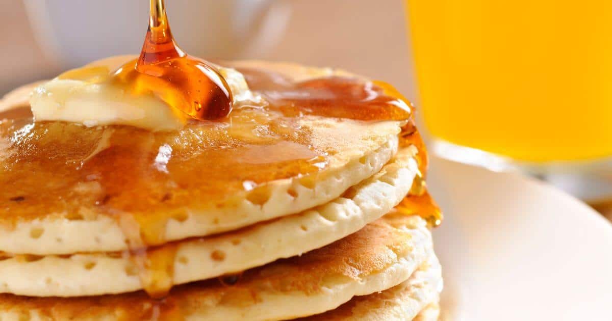 Stack of pancakes with syrup being poured over them for the post titled: Is Aunt Jemima Syrup Gluten-Free?