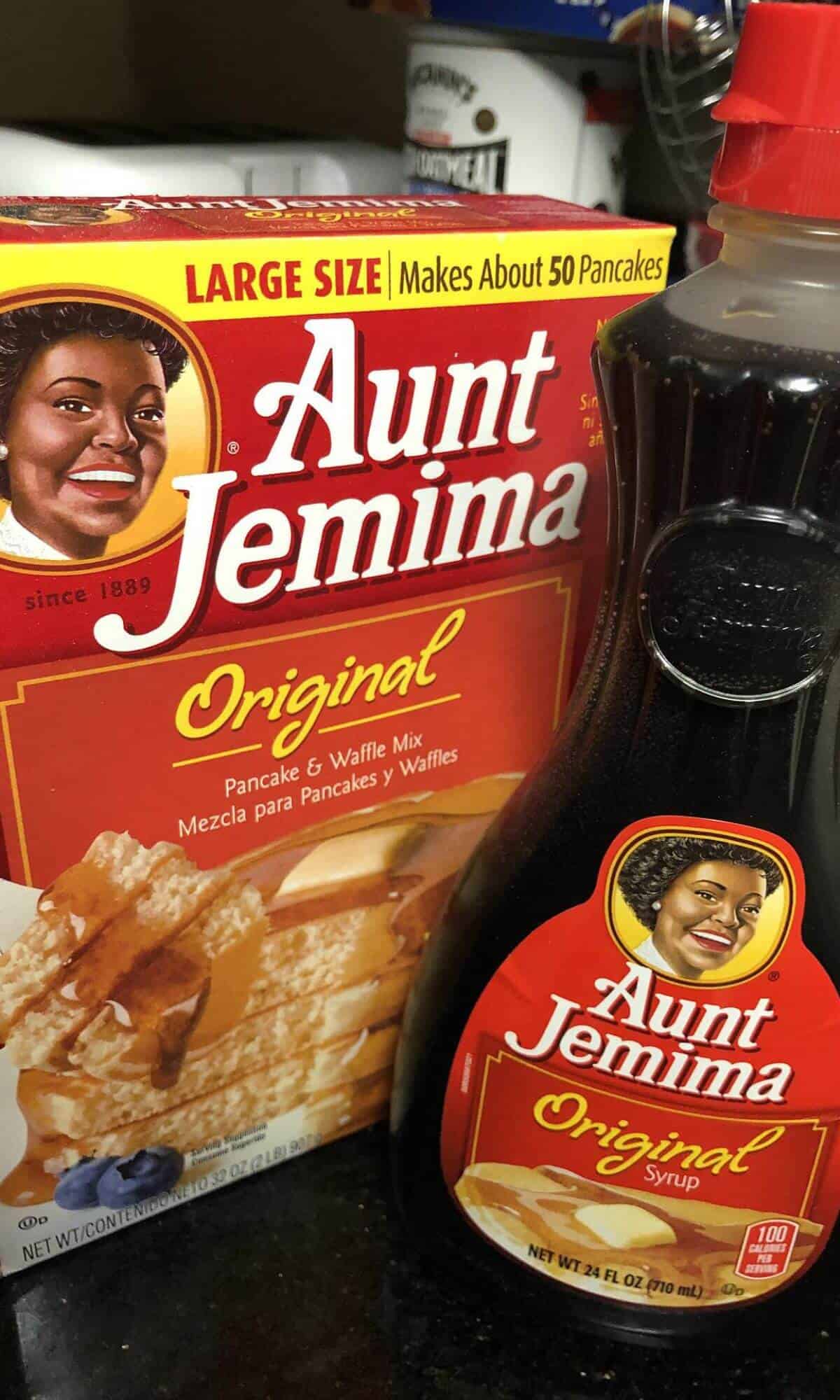 A box of Aunt Jemima pancake mix next to a bottle of Aunt Jemima pancake syrup.