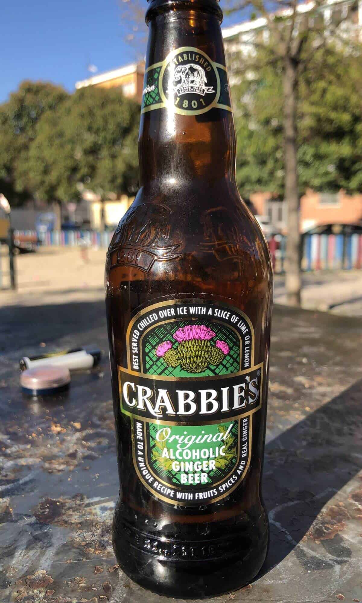 A bottle of Crabbie's Original Alcohol Ginger Beer on an outdoor table.