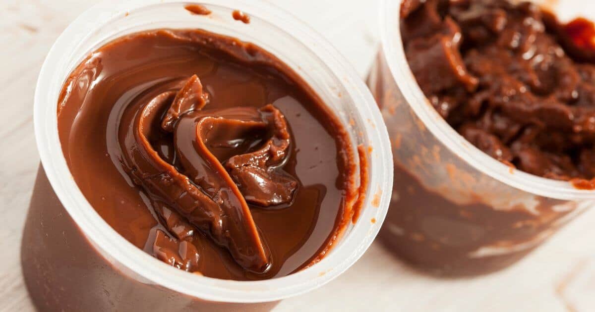 Two chocolate Hunts Snack Pack pudding cups open on a a table.