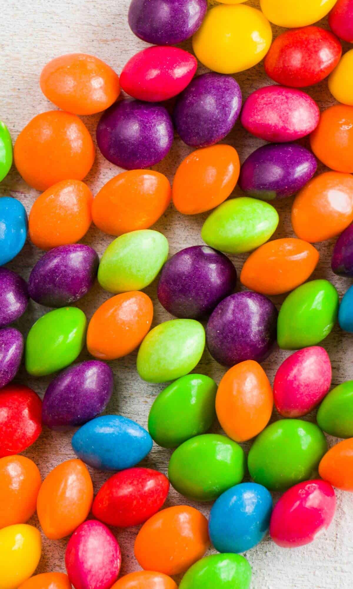 Lots of Skittles candies against a white background for the article titled: Are Skittles Gluten Free?