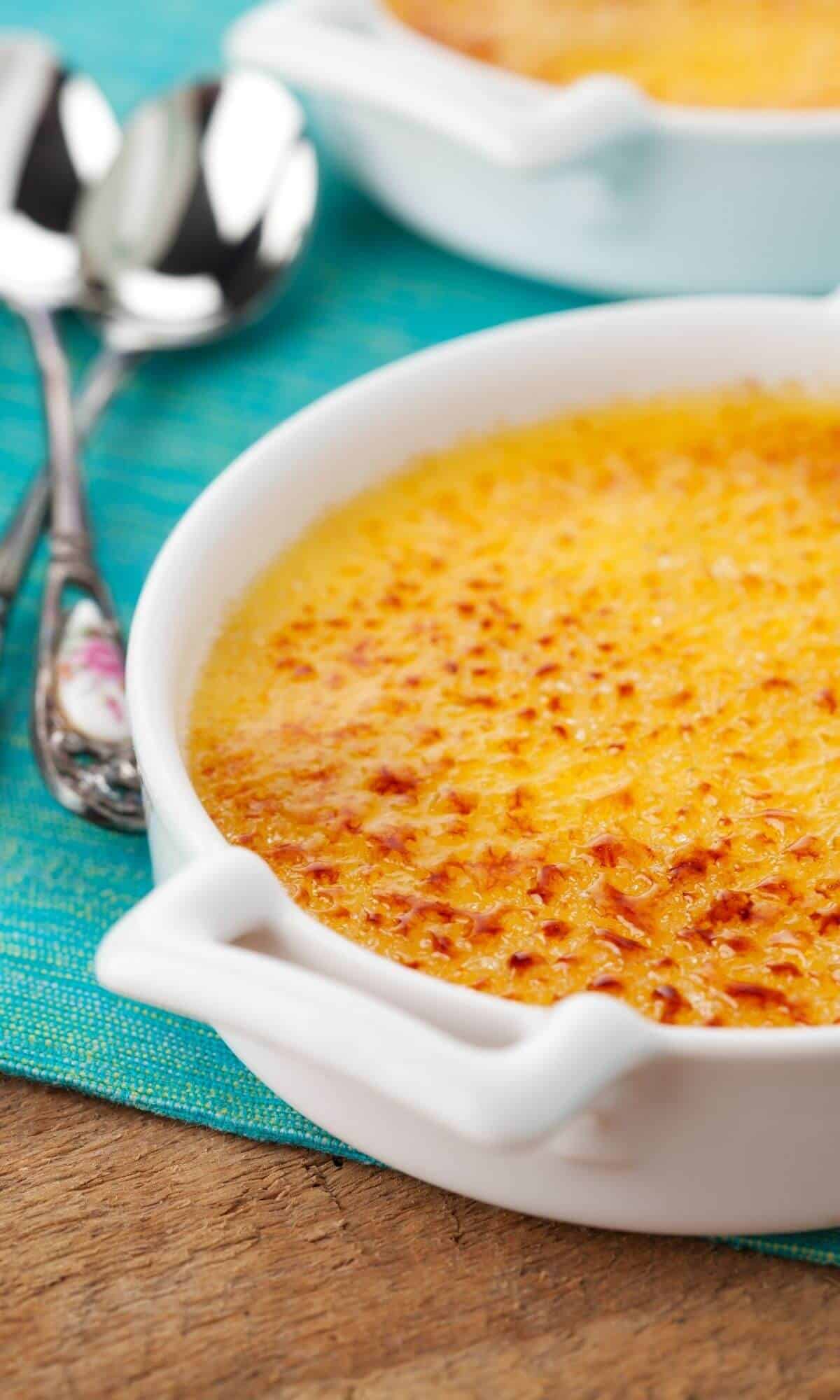 Creme brulee in white dish on table.
