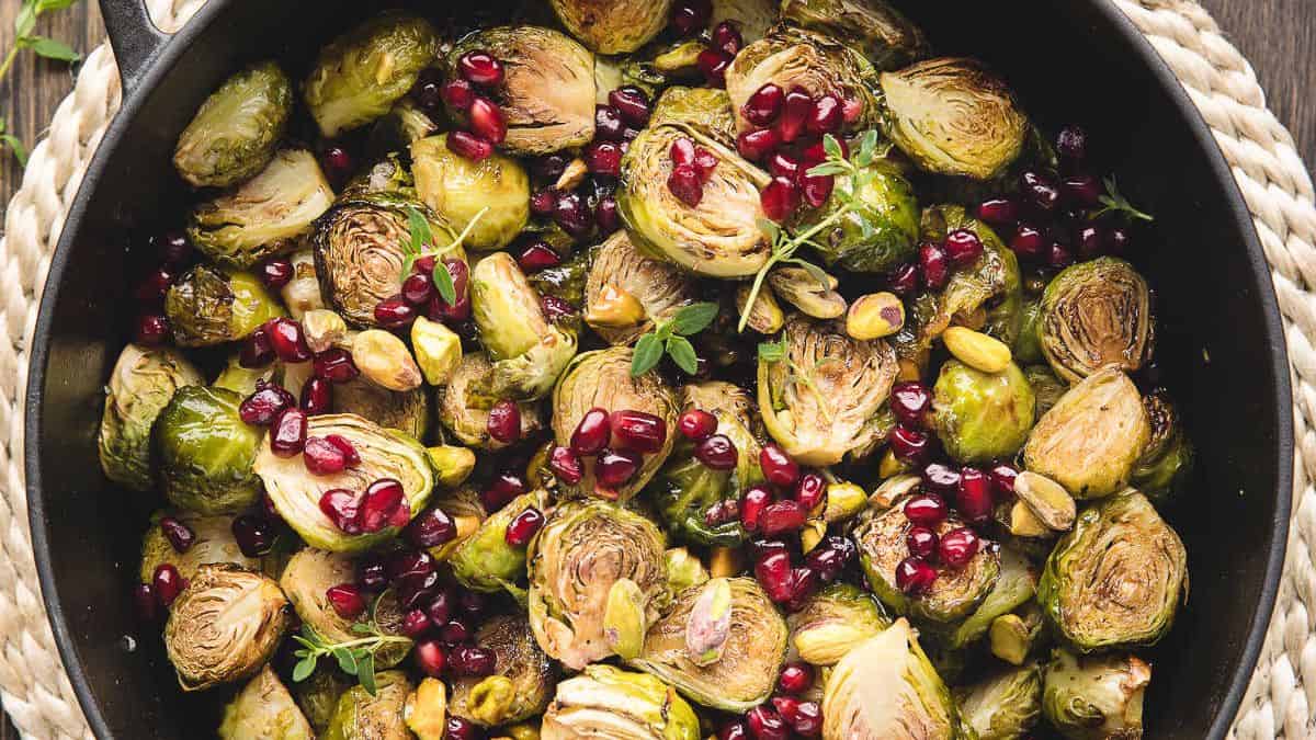 A skillet of brussels sprouts with pomegranate.