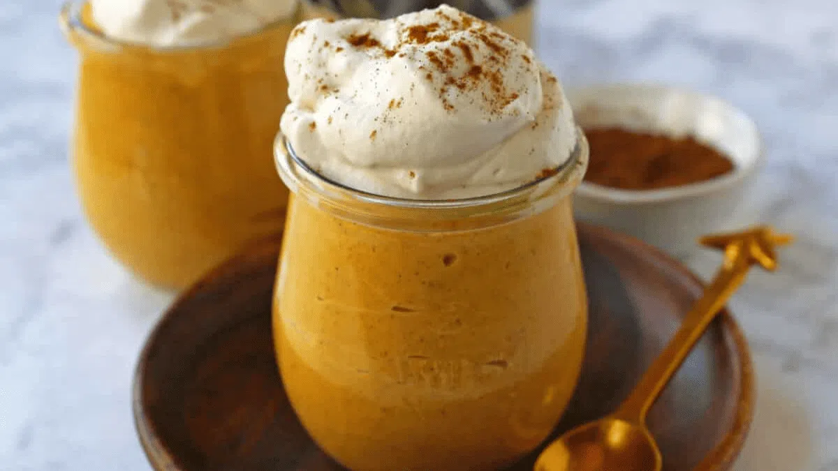 Jars of cheesecake mousse with whipped topping.