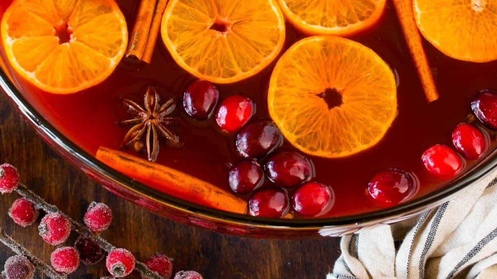 Kinderpunsch in a serving bowl with orange slices, cranberries, cinnamon sticks and star anise.