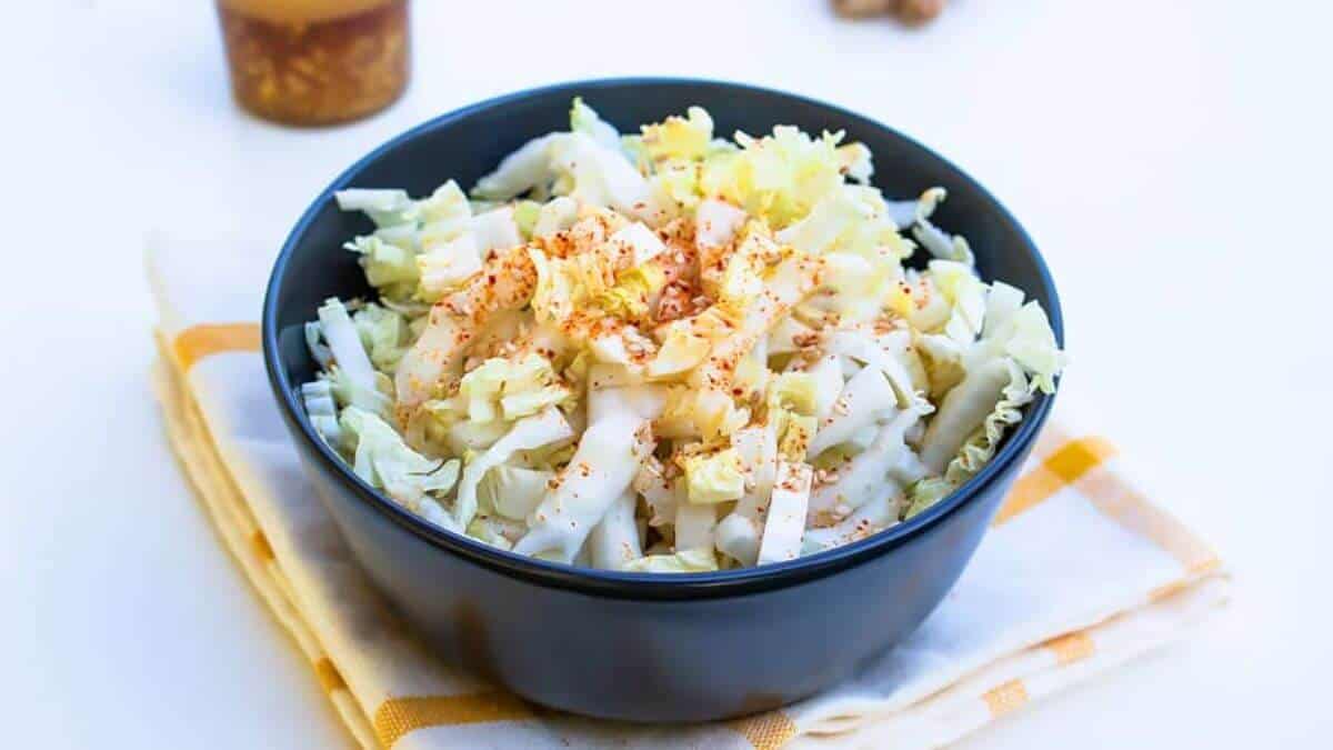 Asian ginger dressing with napa cabbage in a black bowl.