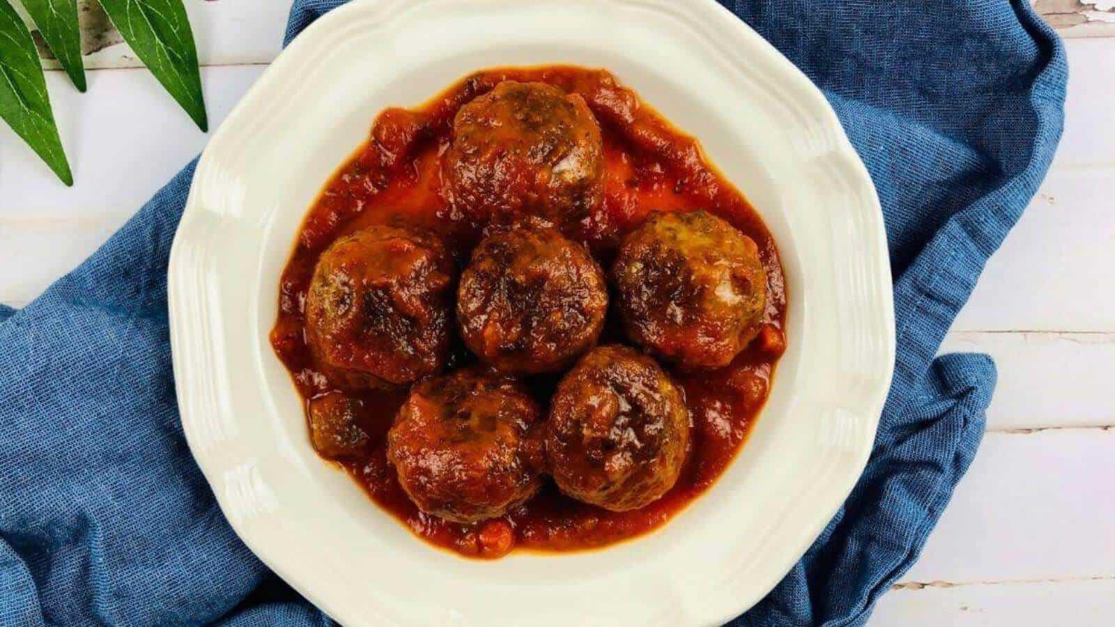 Slow cooker meatballs and sauce in a white bowl.
