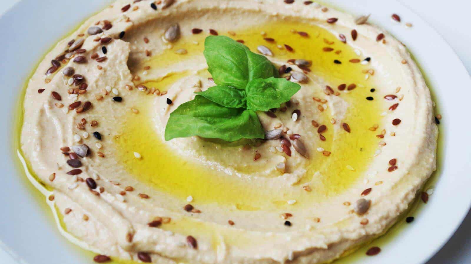 A bowl of hummus drizzled with oil.