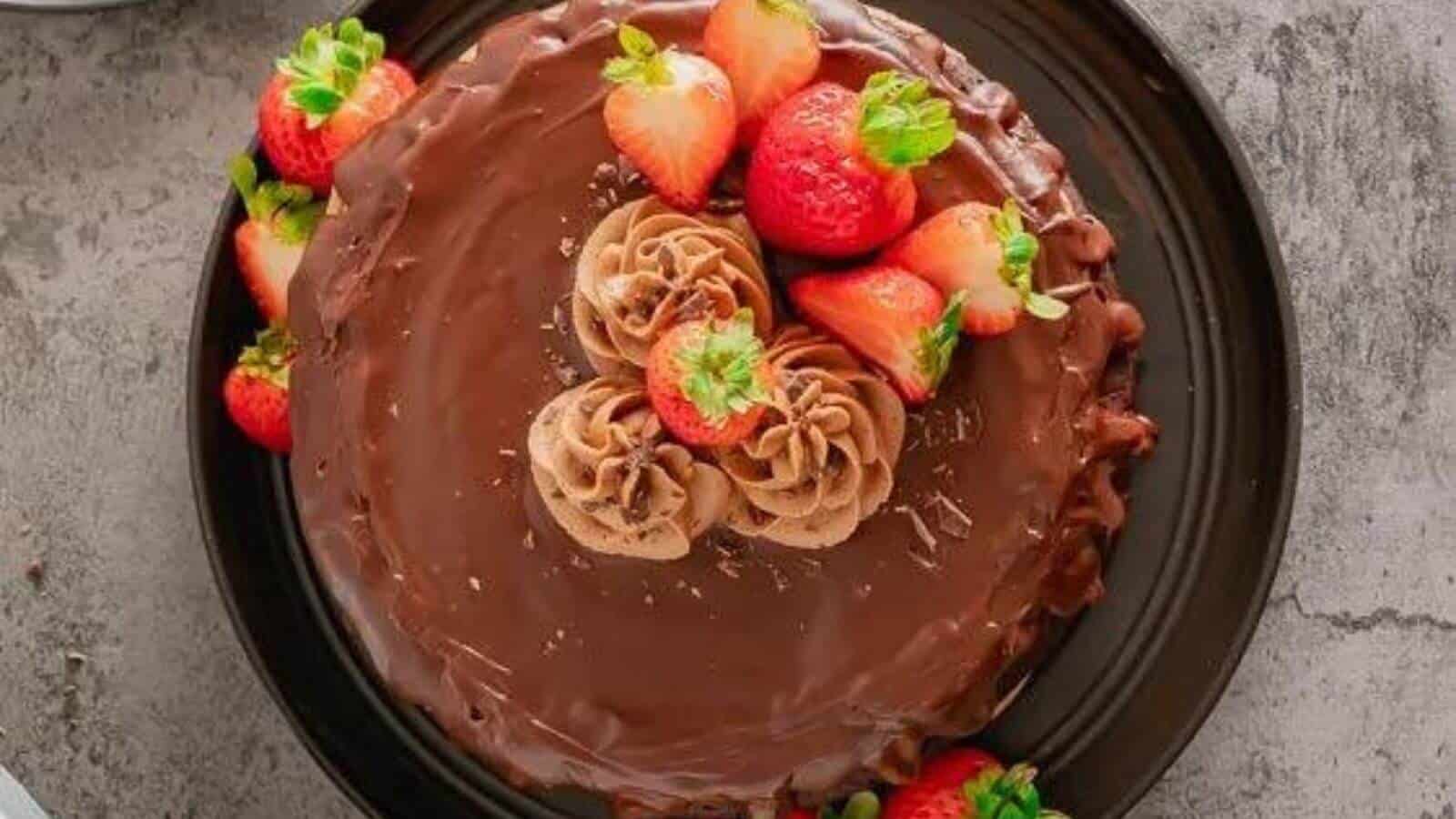 Triple layer flourless chocolate cake with strawberries on top.
