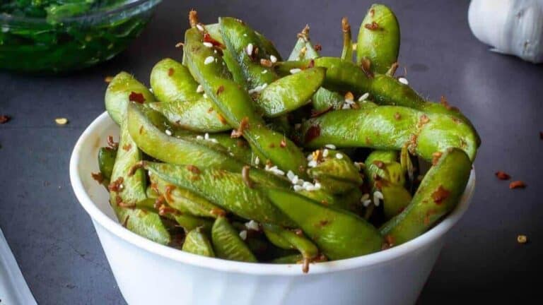 Garlic edamame in a white bowl.