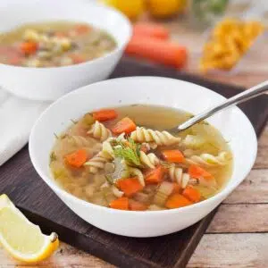 Ground chicken soup in a whitle bowl on a cutting board.