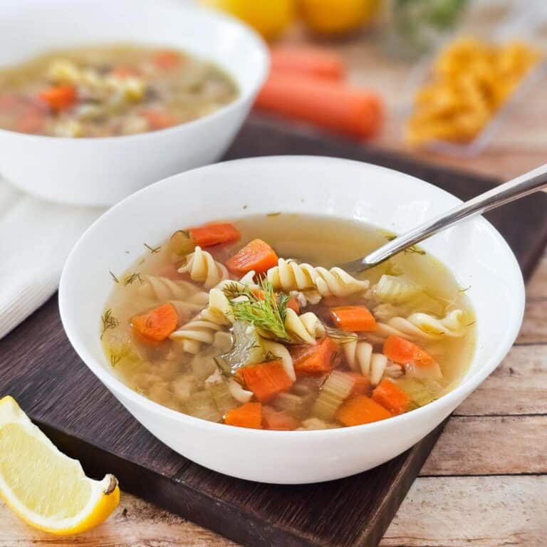 Ground chicken soup in a whitle bowl on a cutting board.