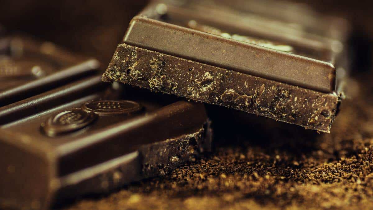 A dark chocolate bar split in half.