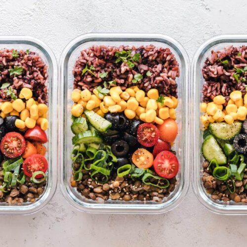 Three glass containers filled with meal-prepped food.