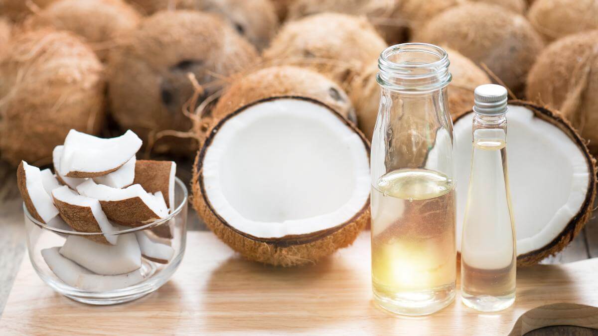 Open coconuts and jars full of coconut oil.