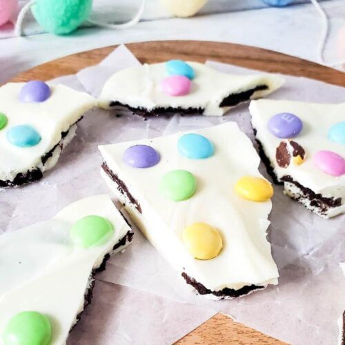 Pieces of Easter Oreo bark on a wooden board.