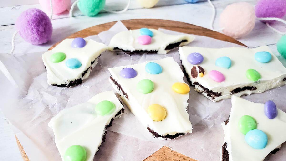 Pieces of Easter Oreo bark on a wooden board.