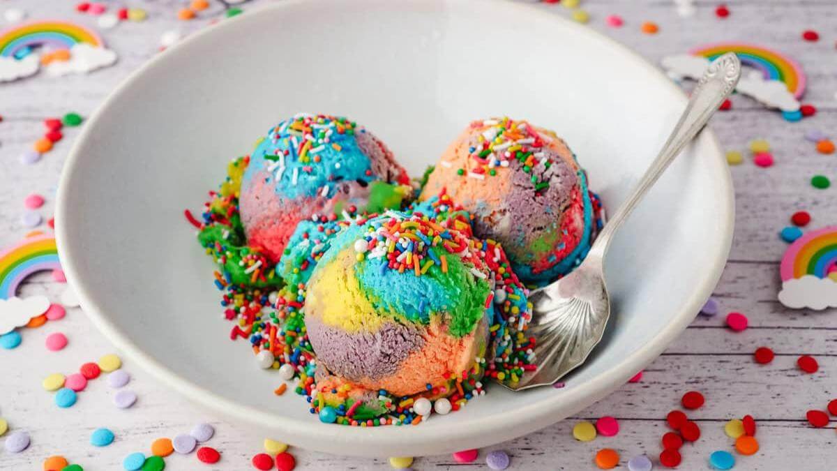 Three scoops of rainbow ice cream in a bowl.