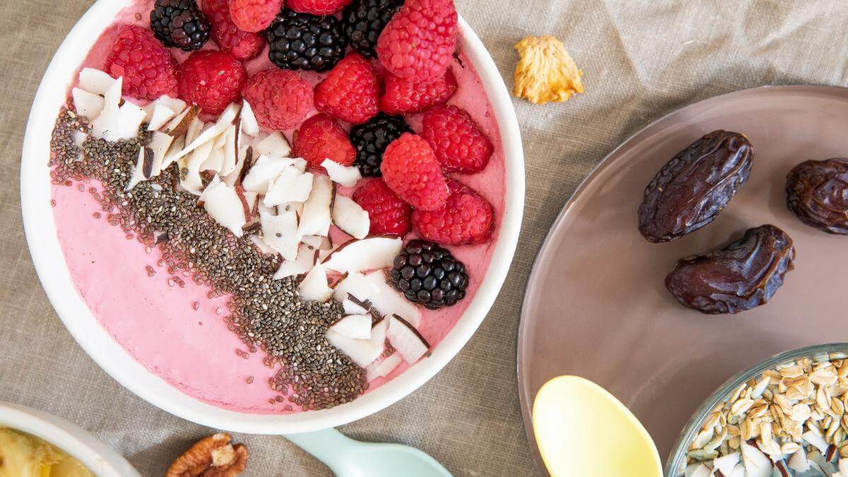 A smoothie bowl with fruit and coconut.