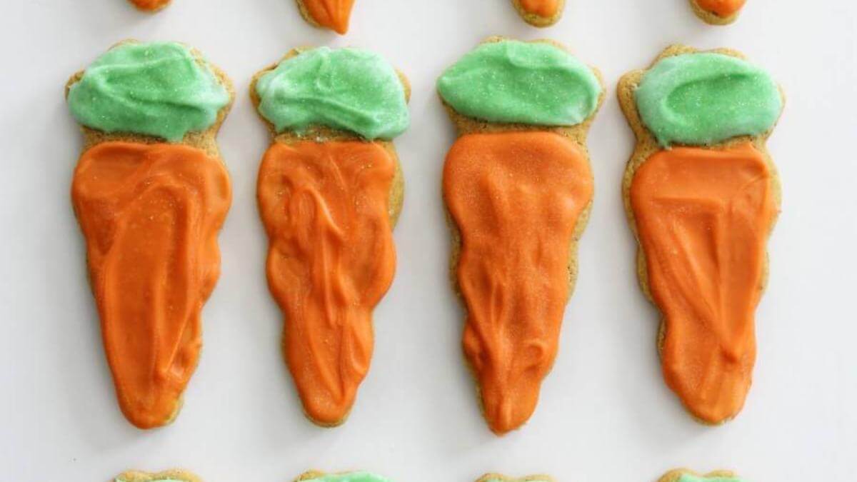 Four carrot cake sugar cookies shaped like carrots.