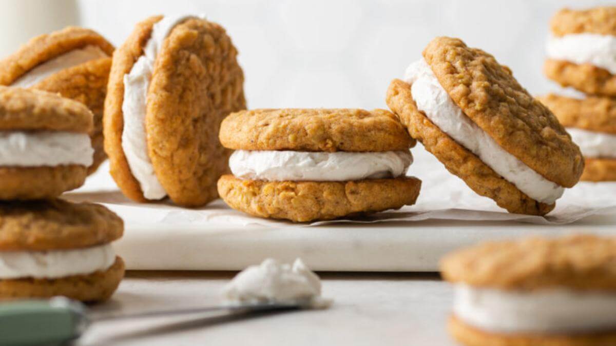 Carrot cake whoopie pies on a plate.