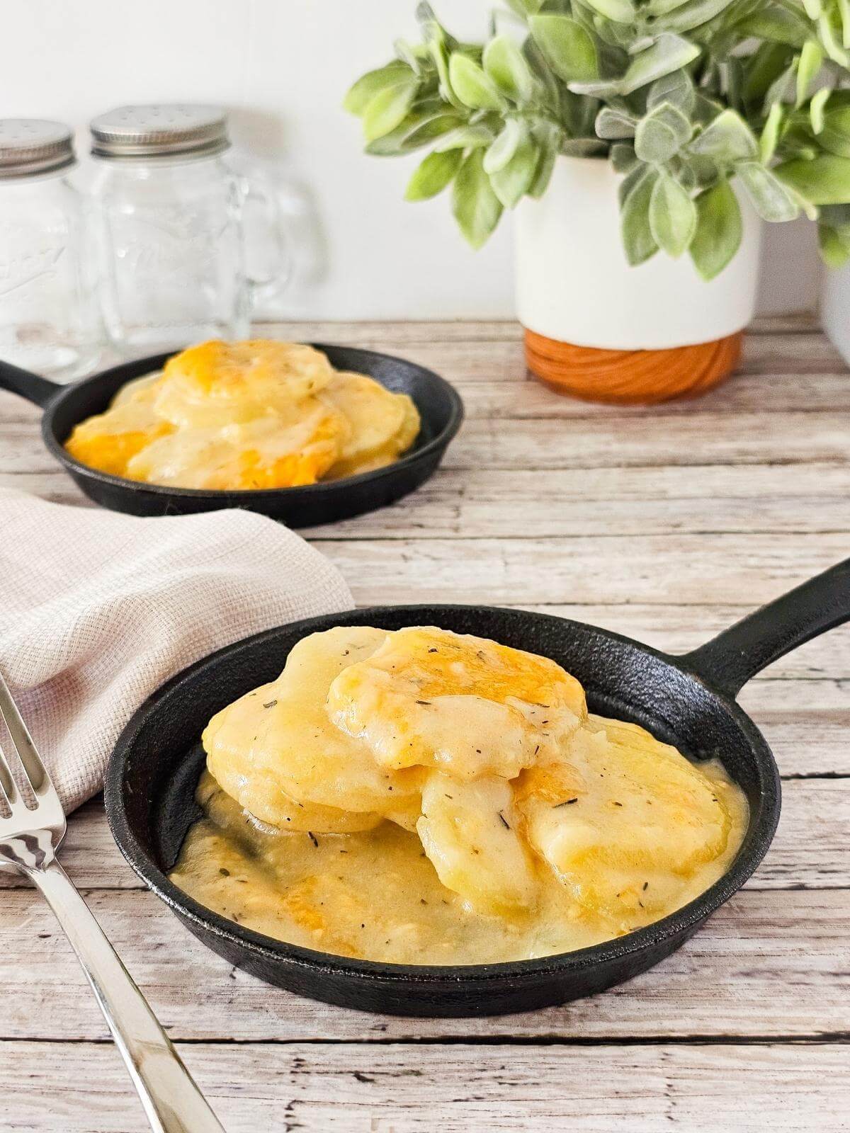 Gluten free scalloped potatoes in a skillet.