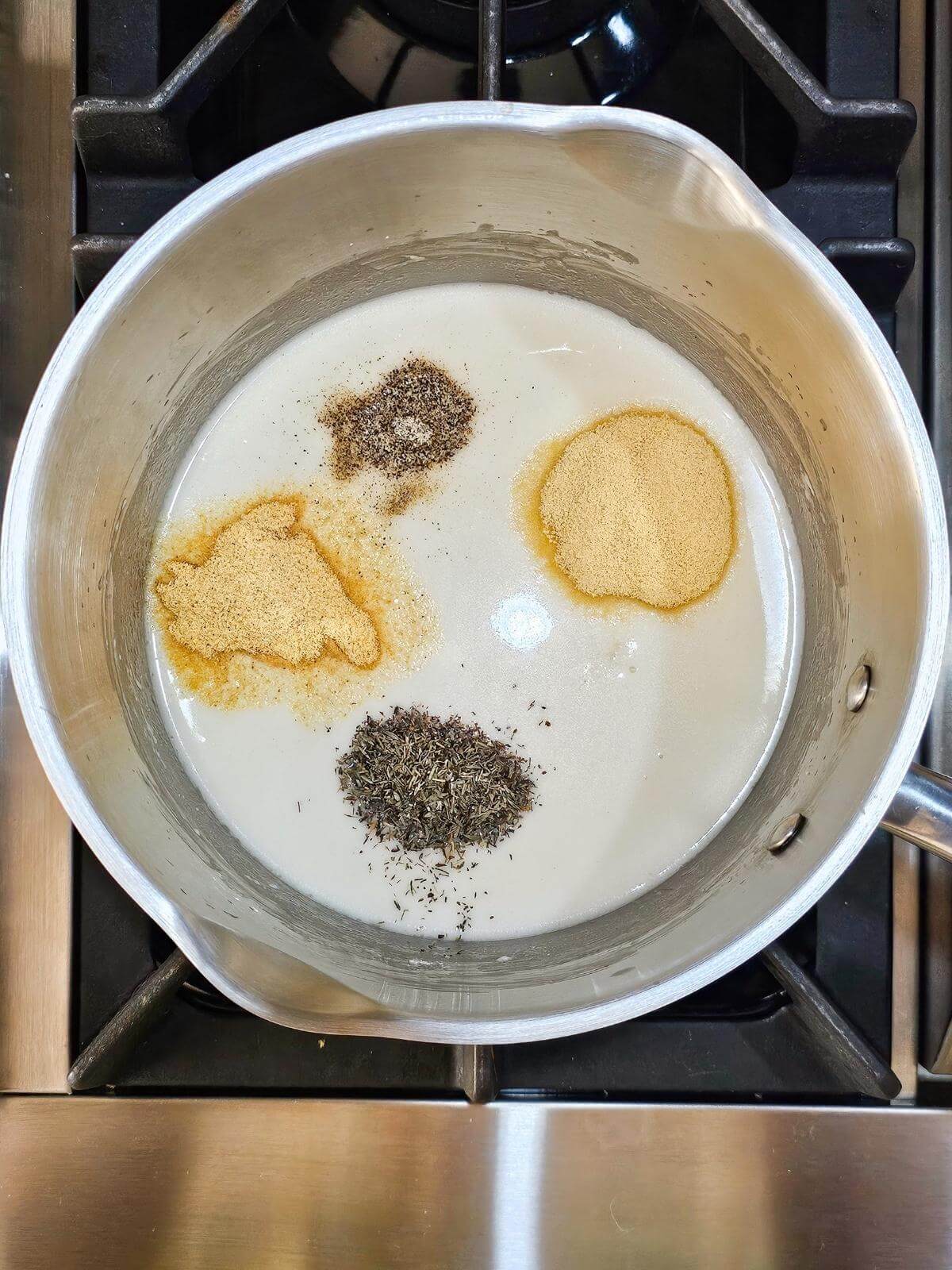Seasonings and milk mixture in a pot.