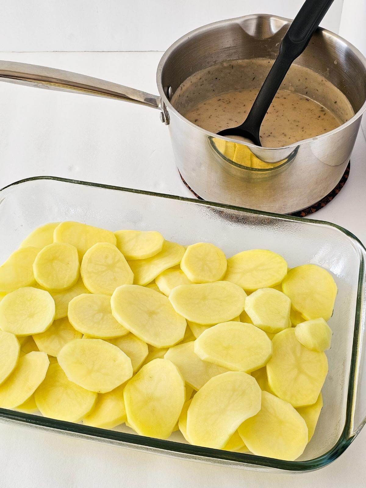 Slices of potatoes layered in a casserole dish.