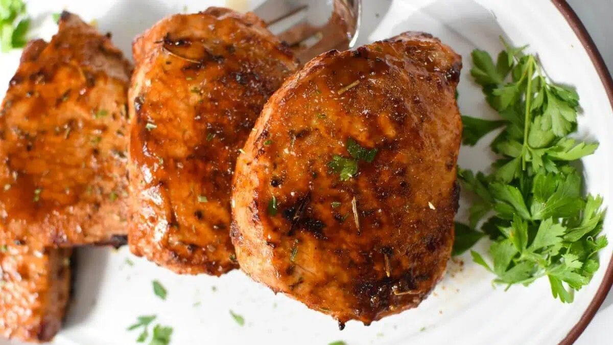Porkchops on a white plate.