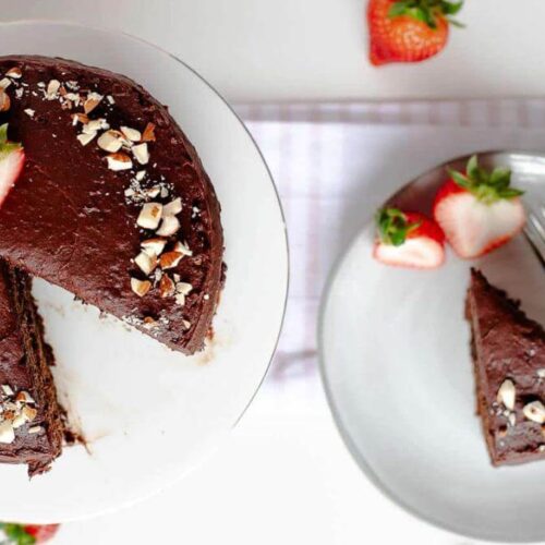 Chocolate cake with a slice taken out and put on a plate.