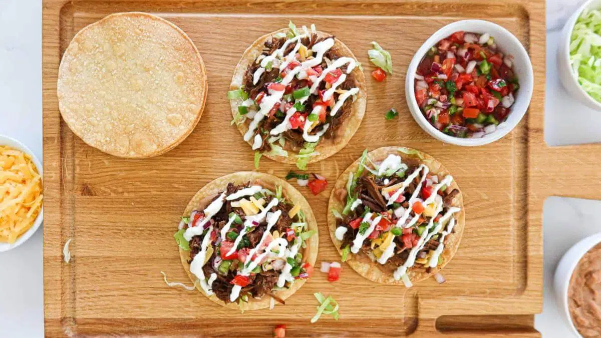 Beef tostadas on a cutting board.