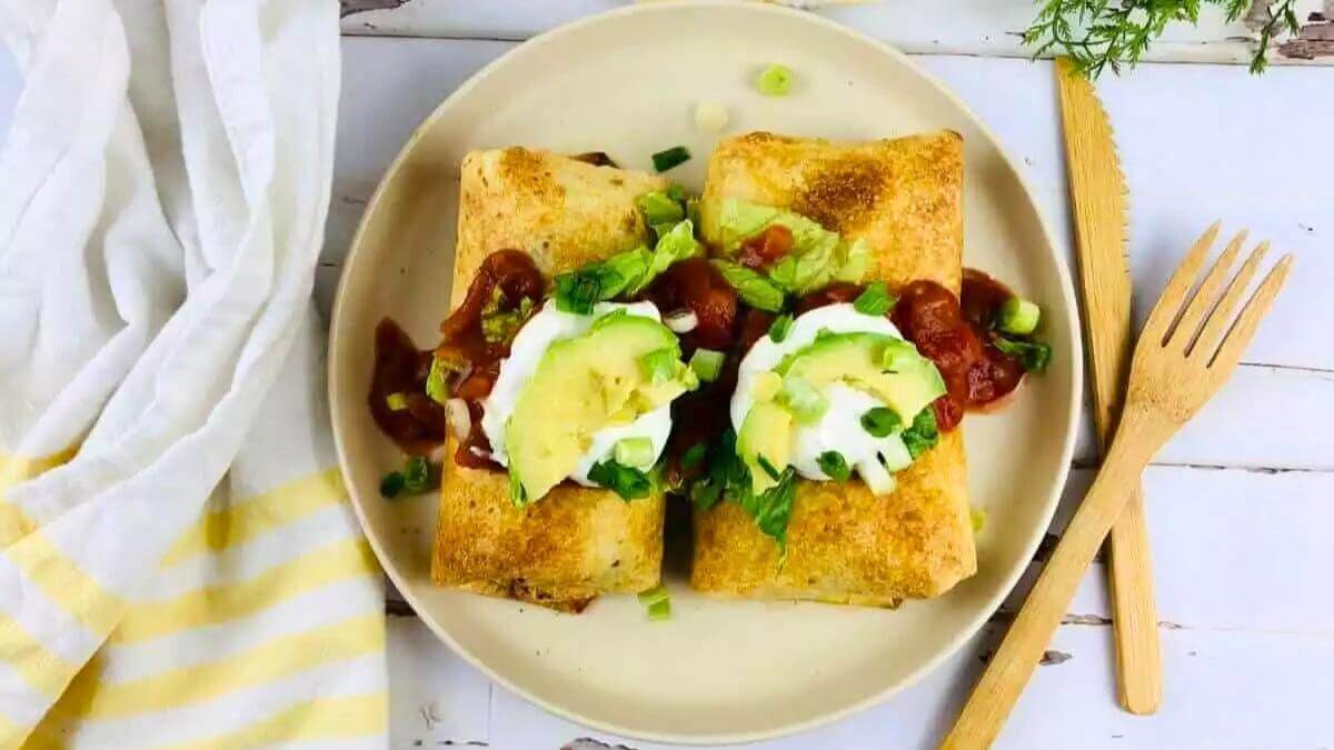 Two chimichangas on a plate.