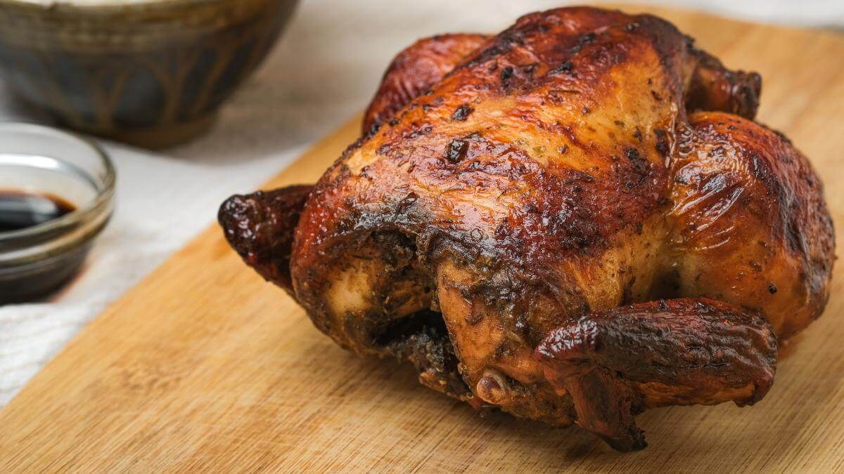 A cooked rotisserie chicken on a counter.