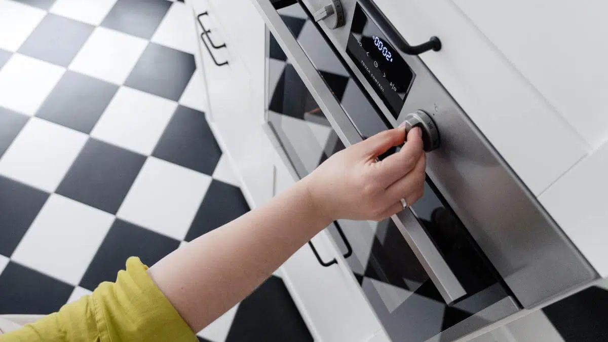 A hand setting the temperature on an oven.