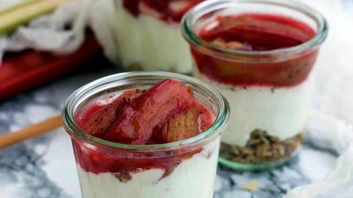 Two glass jars of rhubarb cheesecake.