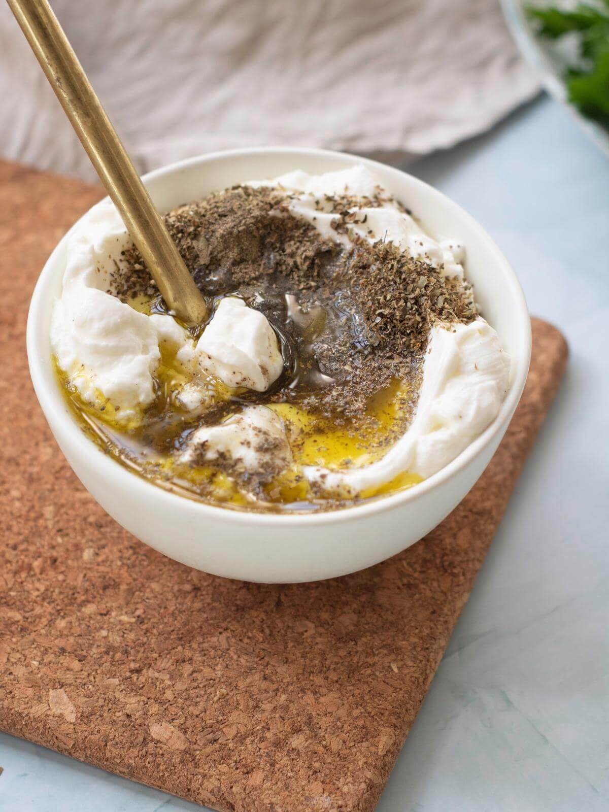 Ingredients for making a yogurt sauce together in a bowl.