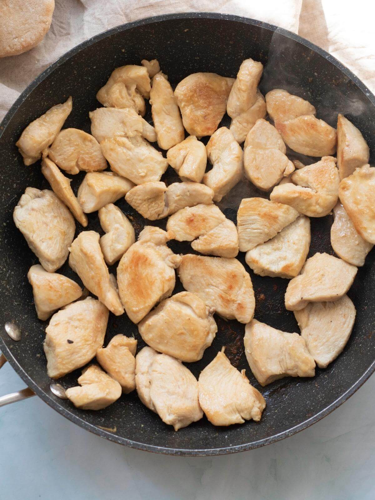 Cooked pieces of chicken in a skillet.