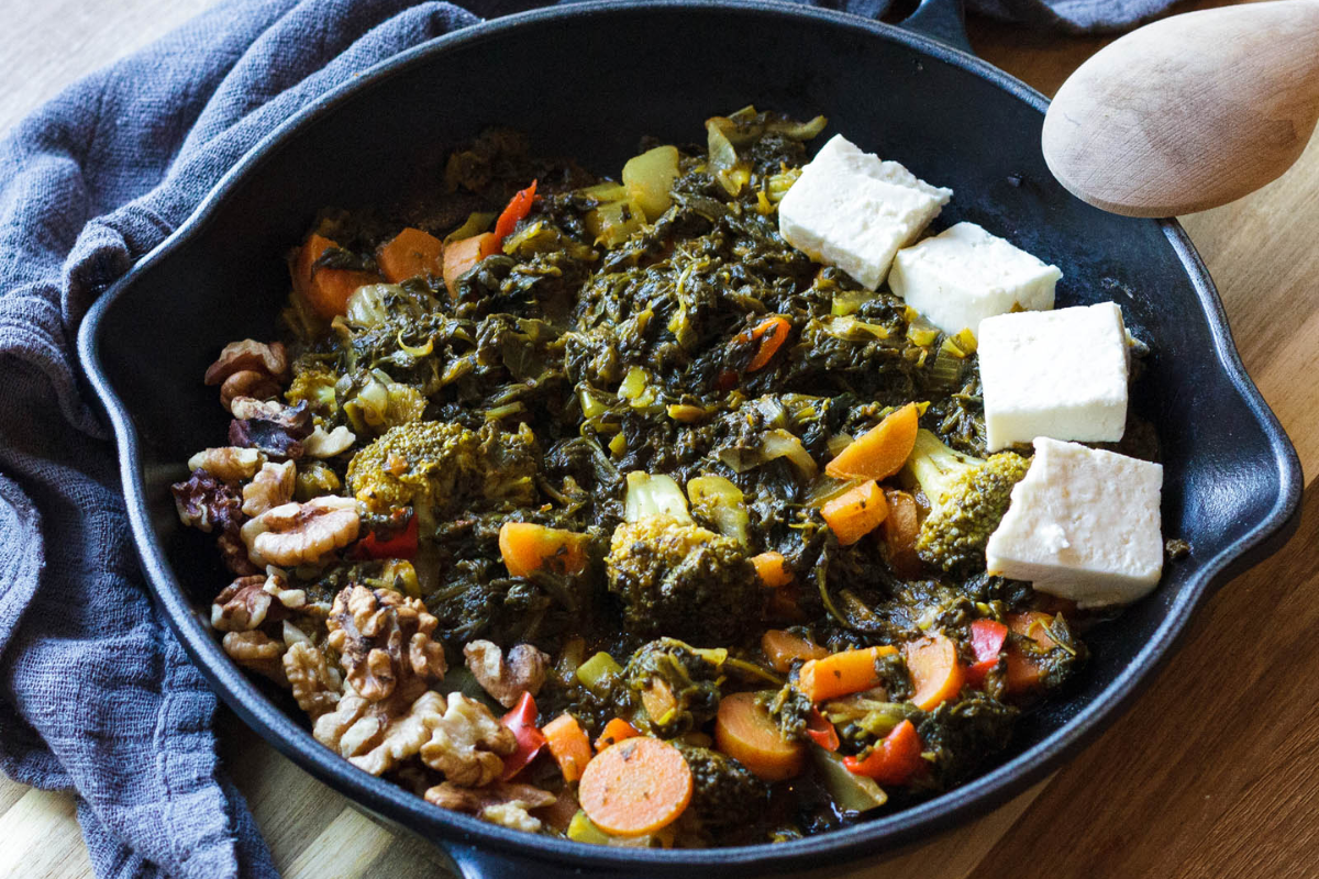 A spinach and broccoli dish in a skillet.