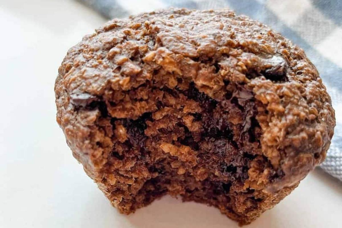 A chocolate oatmeal muffin with a bit out of it.