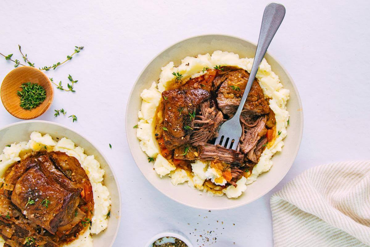 Beef short ribs and mashed potatoes in bowls.