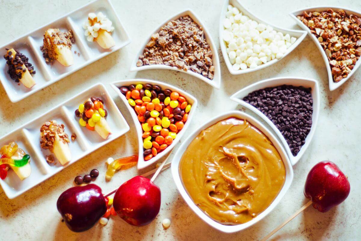 Bowls filled with toppings for caramel apples.