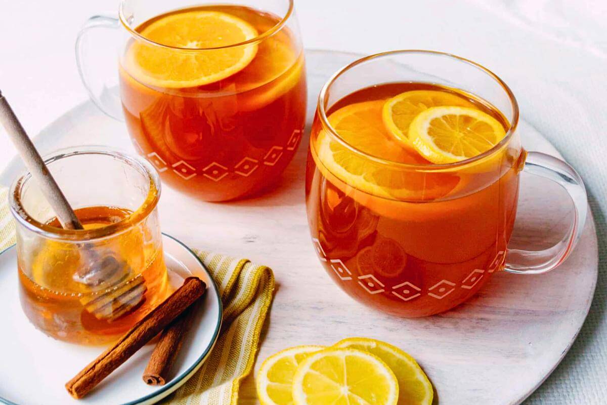 Hot tea in glass mugs with lemon slices.